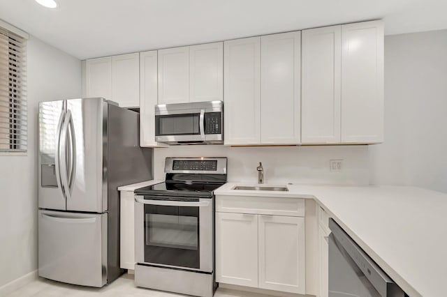 4345 Trevi Ct Unit 203, Lake Worth, FL 33467 - kitchen with stainless steel appliances, a sink, white cabinetry, light countertops, and recessed lighting