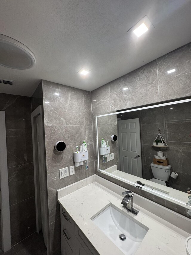 305 E 6th St, Lehigh Acres, FL 33972 - bathroom featuring tile walls, toilet, and vanity
