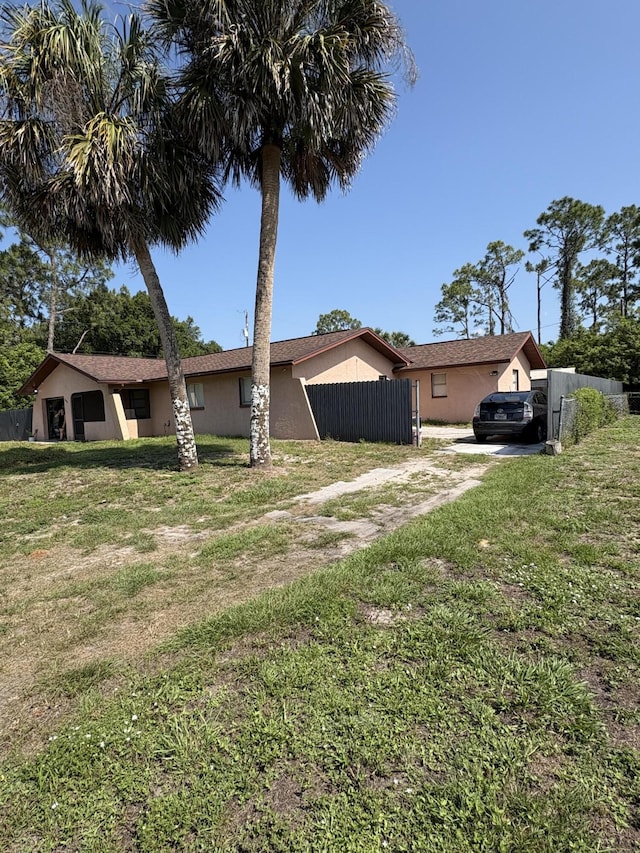 305 E 6th St, Lehigh Acres, FL 33972 - rear view of property featuring stucco siding