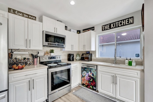 22360 Overture Cir, Boca Raton, FL 33428 - kitchen with stainless steel appliances, backsplash, white cabinets, and light countertops