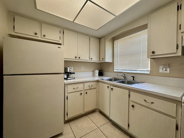 2842 Crosley Dr W Unit B, West Palm Beach, FL 33415 - kitchen featuring freestanding refrigerator, a sink, light countertops, light tile patterned floors, and cream cabinetry