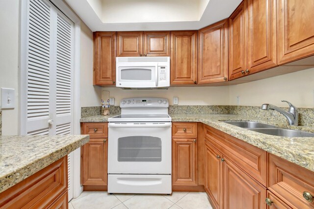 5505 N Ocean Blvd Unit 13-105, Ocean Ridge, FL 33435 - kitchen with white appliances, a sink, light tile patterned floors, and brown cabinetry
