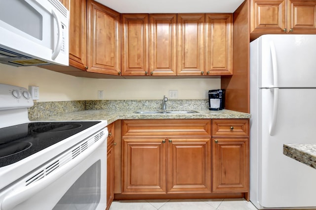 5505 N Ocean Blvd Unit 13-105, Ocean Ridge, FL 33435 - kitchen with white appliances, a sink, brown cabinetry, light tile patterned flooring, and light stone countertops