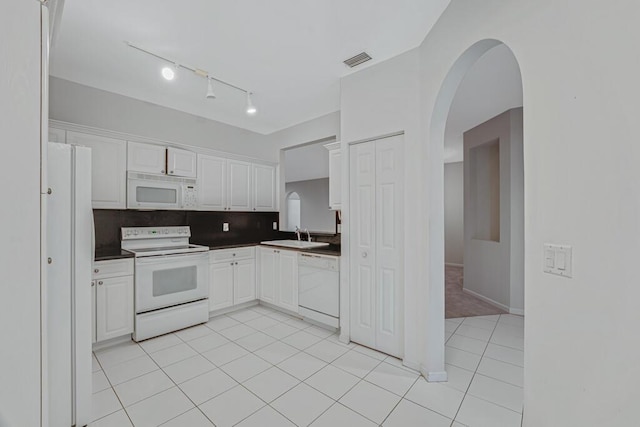 7886 Laina Ln Unit 2, Boynton Beach, FL 33437 - kitchen featuring white appliances, arched walkways, white cabinets, decorative backsplash, and light tile patterned floors