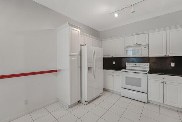 7886 Laina Ln Unit 2, Boynton Beach, FL 33437 - kitchen with white appliances, rail lighting, white cabinetry, tasteful backsplash, and dark countertops
