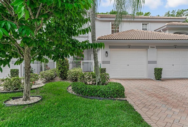 7886 Laina Ln Unit 2, Boynton Beach, FL 33437 - view of front facade with stucco siding, a tiled roof, a garage, decorative driveway, and a front lawn