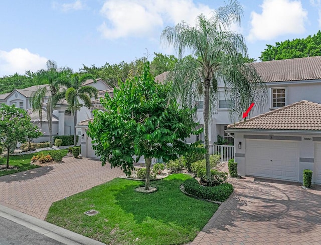 7886 Laina Ln Unit 2, Boynton Beach, FL 33437 - mediterranean / spanish-style home featuring a tiled roof, stucco siding, decorative driveway, a front lawn, and an attached garage
