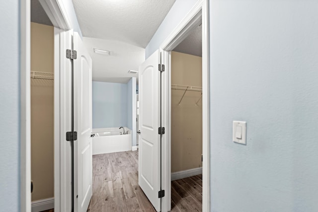 4672 SW Wade Dr, Port Saint Lucie, FL 34953 - hallway with wood finished floors, baseboards, and a textured ceiling