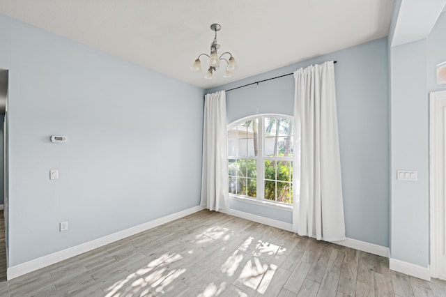 4672 SW Wade Dr, Port Saint Lucie, FL 34953 - spare room with a chandelier, baseboards, and light wood-style floors