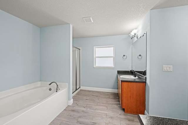 4672 SW Wade Dr, Port Saint Lucie, FL 34953 - full bathroom with a garden tub, vanity, a stall shower, wood finished floors, and a textured ceiling