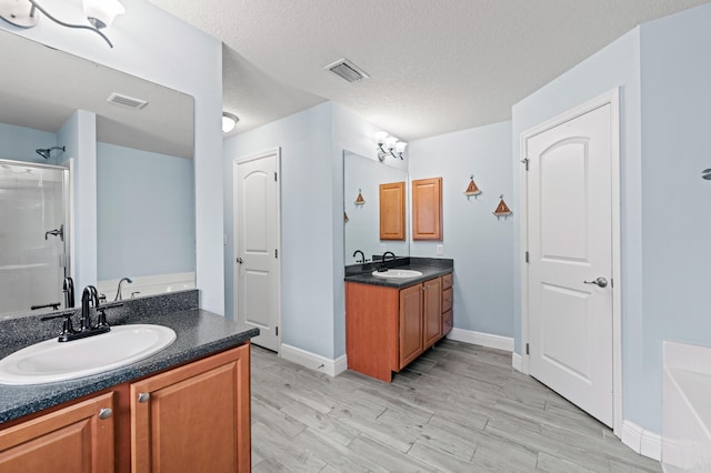 4672 SW Wade Dr, Port Saint Lucie, FL 34953 - bathroom featuring two vanities, a garden tub, wood finished floors, a shower, and baseboards