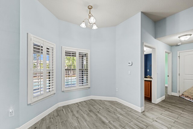 4672 SW Wade Dr, Port Saint Lucie, FL 34953 - unfurnished dining area with light wood-style floors, a chandelier, baseboards, and a high ceiling