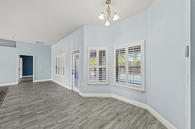 4672 SW Wade Dr, Port Saint Lucie, FL 34953 - unfurnished room with wood finished floors, baseboards, and a chandelier