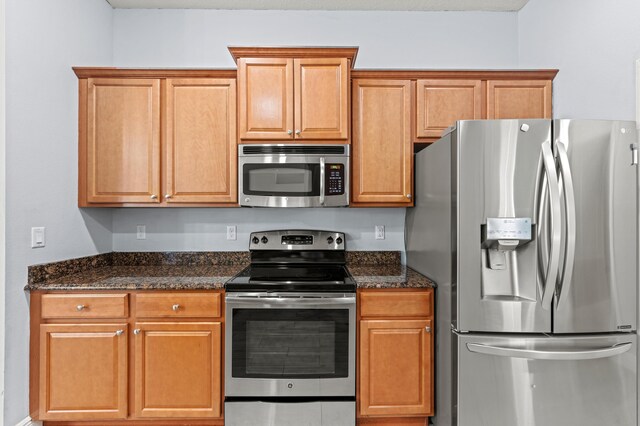 4672 SW Wade Dr, Port Saint Lucie, FL 34953 - kitchen with appliances with stainless steel finishes and dark stone countertops
