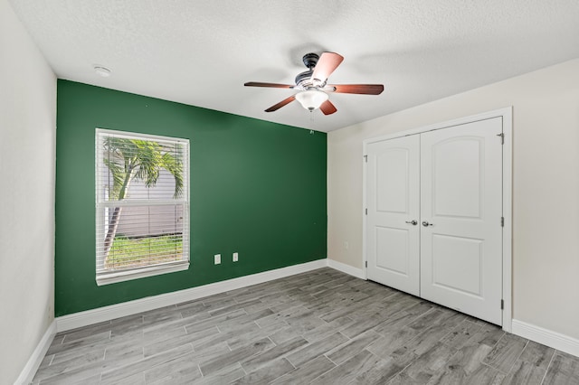 4672 SW Wade Dr, Port Saint Lucie, FL 34953 - unfurnished bedroom with wood finished floors, a textured ceiling, a closet, and baseboards