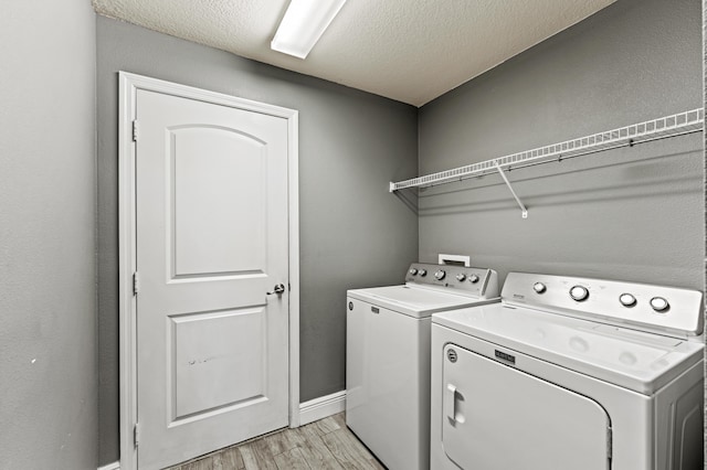 4672 SW Wade Dr, Port Saint Lucie, FL 34953 - laundry room with separate washer and dryer, light wood-style floors, a textured ceiling, and baseboards