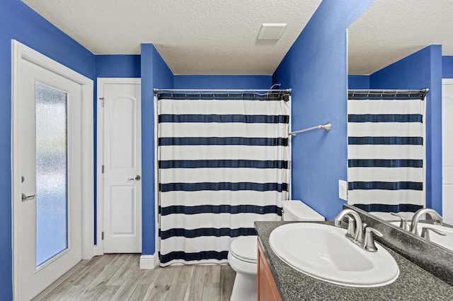 4672 SW Wade Dr, Port Saint Lucie, FL 34953 - full bath featuring vanity, toilet, wood finished floors, a textured ceiling, and curtained shower