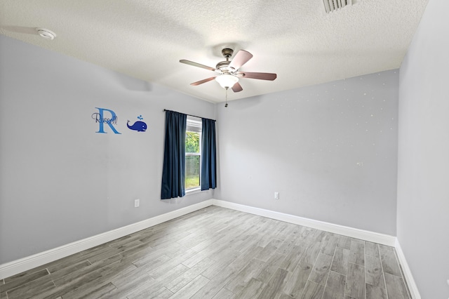 4672 SW Wade Dr, Port Saint Lucie, FL 34953 - spare room featuring wood finished floors, ceiling fan, a textured ceiling, baseboards, and a smoke detector