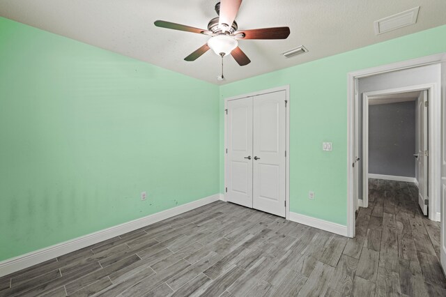 4672 SW Wade Dr, Port Saint Lucie, FL 34953 - unfurnished bedroom with wood finished floors, baseboards, a closet, and a ceiling fan