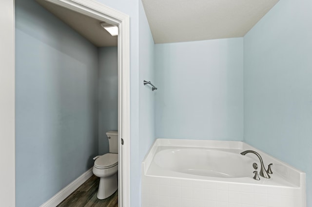 4672 SW Wade Dr, Port Saint Lucie, FL 34953 - full bathroom featuring toilet, a garden tub, wood finished floors, and baseboards