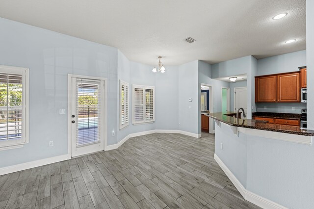4672 SW Wade Dr, Port Saint Lucie, FL 34953 - kitchen with a chandelier, plenty of natural light, baseboards, a textured ceiling, and recessed lighting