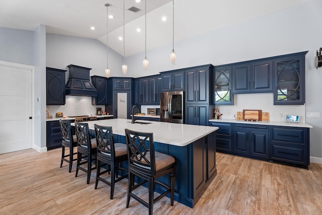 10 Copaire Rd, Sewalls Point, FL 34996 - kitchen with stainless steel fridge with ice dispenser, custom exhaust hood, blue cabinets, a sink, and light countertops