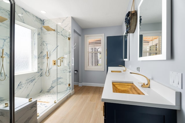 10 Copaire Rd, Sewalls Point, FL 34996 - bathroom with double vanity, a marble finish shower, wood finished floors, and baseboards