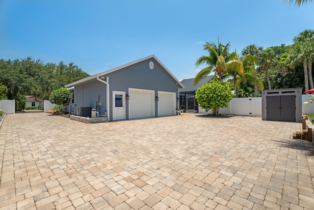 10 Copaire Rd, Sewalls Point, FL 34996 - view of side of property with a gate, a garage, driveway, and central air condition unit