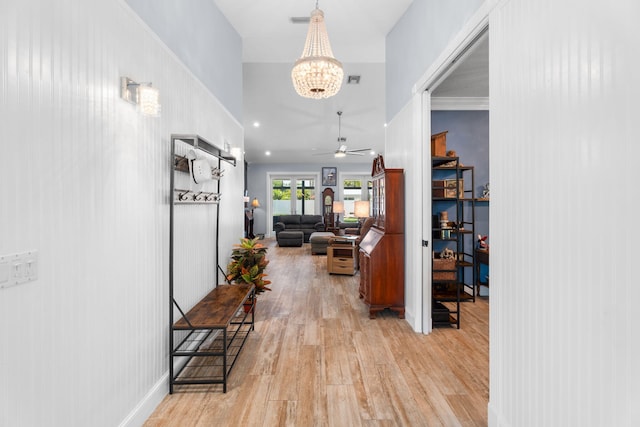 10 Copaire Rd, Sewalls Point, FL 34996 - hallway featuring light wood finished floors and a chandelier