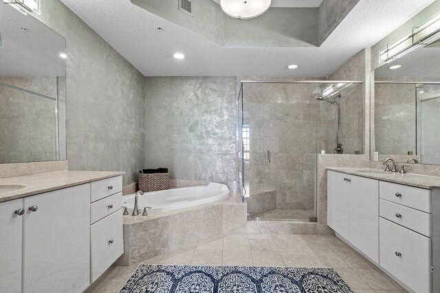 701 S Olive Ave Unit 923, West Palm Beach, FL 33401 - full bathroom featuring a stall shower, a bath, two vanities, tile patterned flooring, and recessed lighting
