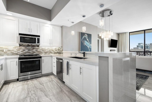 701 S Olive Ave Unit 923, West Palm Beach, FL 33401 - kitchen featuring appliances with stainless steel finishes, a sink, a peninsula, backsplash, and recessed lighting