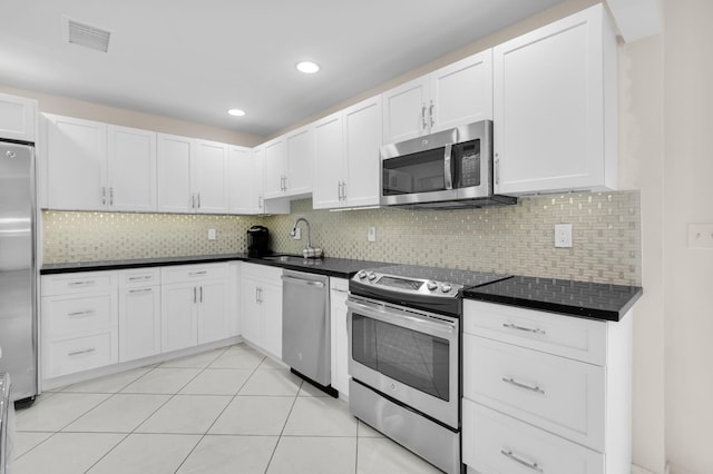 12 Westgate Ln Unit C, Boynton Beach, FL 33436 - kitchen featuring stainless steel appliances, a sink, dark countertops, decorative backsplash, and recessed lighting