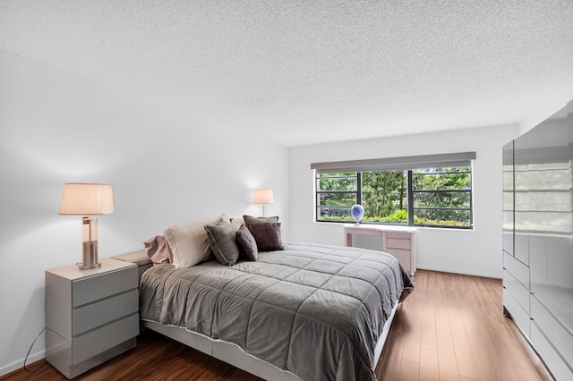 12 Westgate Ln Unit C, Boynton Beach, FL 33436 - bedroom featuring wood finished floors, a textured ceiling, and baseboards