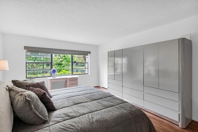 12 Westgate Ln Unit C, Boynton Beach, FL 33436 - bedroom featuring a textured ceiling and wood finished floors