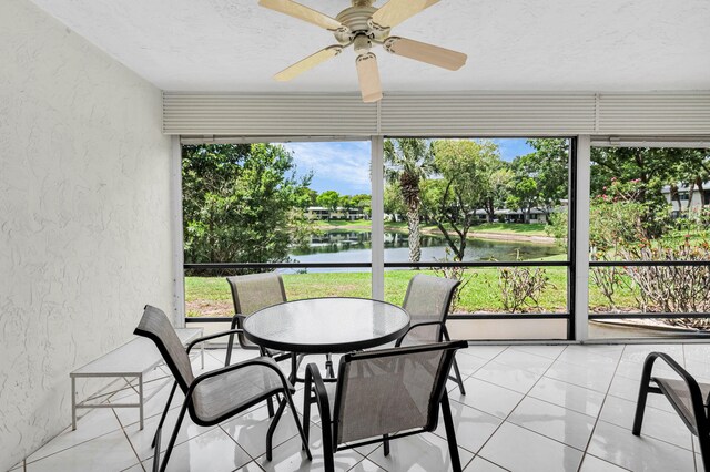 12 Westgate Ln Unit C, Boynton Beach, FL 33436 - sunroom featuring a textured wall, a water view, a ceiling fan, and a textured ceiling