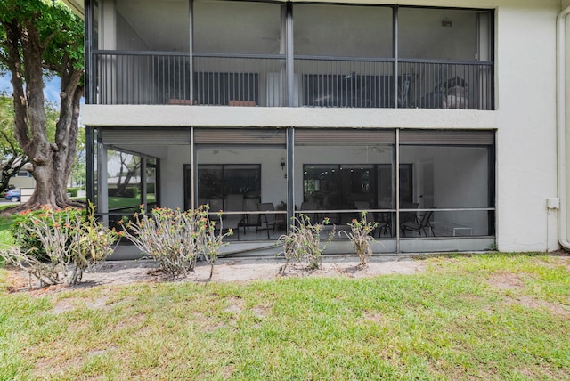 12 Westgate Ln Unit C, Boynton Beach, FL 33436 - back of property with a lawn, a sunroom, and stucco siding