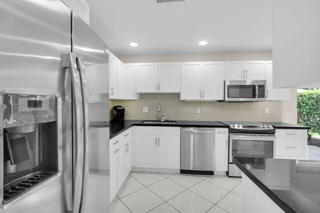 12 Westgate Ln Unit C, Boynton Beach, FL 33436 - kitchen with stainless steel appliances, a sink, white cabinetry, decorative backsplash, and recessed lighting