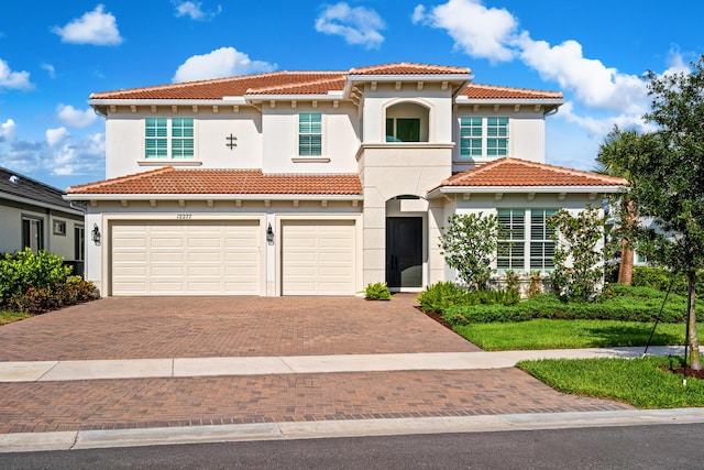 12277 Waterstone Cir, Palm Beach Gardens, FL 33412 - mediterranean / spanish home featuring decorative driveway, a tile roof, a garage, and stucco siding