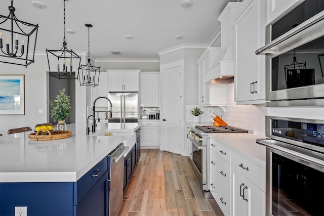 12277 Waterstone Cir, Palm Beach Gardens, FL 33412 - kitchen featuring appliances with stainless steel finishes, blue cabinets, a sink, light countertops, and a chandelier