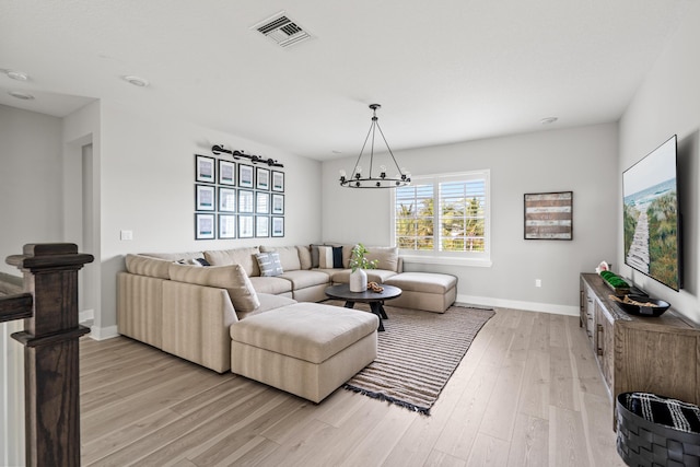 12277 Waterstone Cir, Palm Beach Gardens, FL 33412 - living room featuring a chandelier, light wood-type flooring, and baseboards