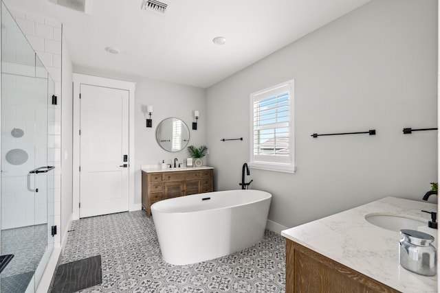 12277 Waterstone Cir, Palm Beach Gardens, FL 33412 - full bathroom with two vanities, a stall shower, baseboards, and a freestanding tub