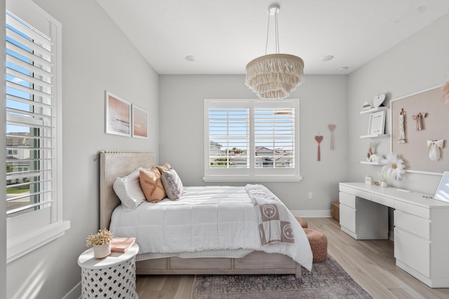 12277 Waterstone Cir, Palm Beach Gardens, FL 33412 - bedroom with light wood finished floors, a chandelier, baseboards, and a desk