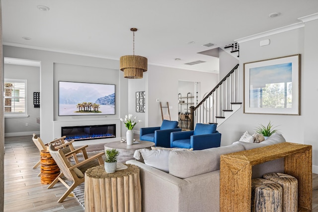 12277 Waterstone Cir, Palm Beach Gardens, FL 33412 - living room featuring baseboards, ornamental molding, a glass covered fireplace, light wood finished floors, and stairs