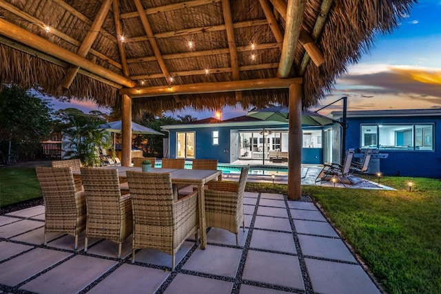 5031 Van Buren Rd, Delray Beach, FL 33484 - patio terrace at dusk featuring a gazebo, a patio, a lawn, an outdoor pool, and outdoor dining space