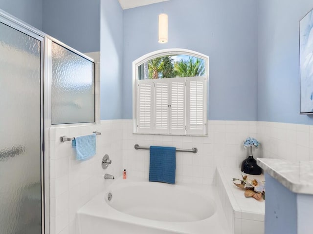 470 NW Gibraltar Ct, Port Saint Lucie, FL 34986 - full bath with a bath, a shower stall, tile walls, and wainscoting