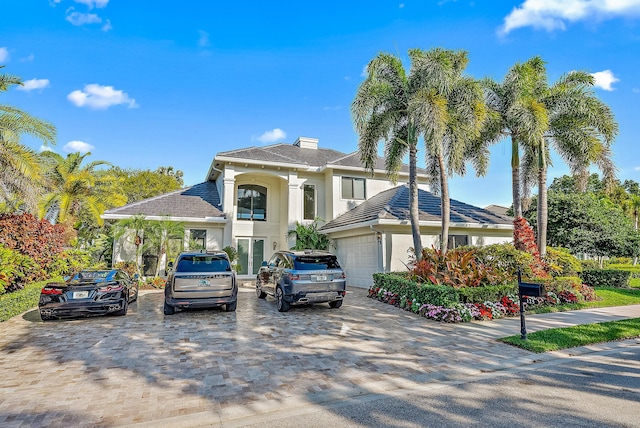 125 Pembroke Dr, Palm Beach Gardens, FL 33418 - view of front of property featuring stucco siding, a garage, driveway, and a chimney
