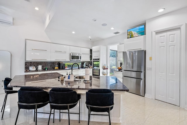 125 Pembroke Dr, Palm Beach Gardens, FL 33418 - kitchen featuring appliances with stainless steel finishes, modern cabinets, a kitchen breakfast bar, a wall unit AC, and white cabinets