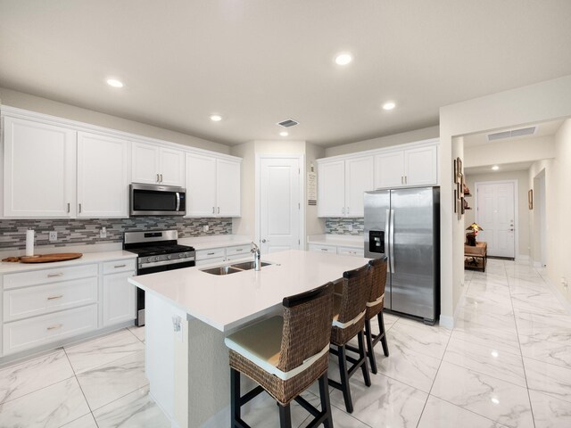 10621 SW Morning Glory Dr, Port Saint Lucie, FL 34987 - kitchen with stainless steel appliances, light marble finish floors, a sink, recessed lighting, and an island with sink
