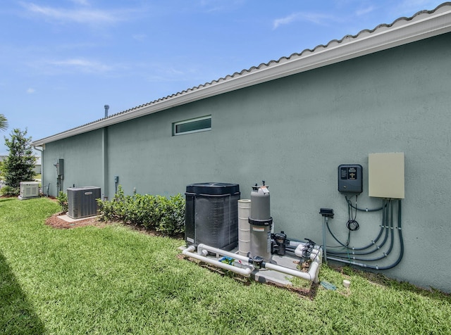 10621 SW Morning Glory Dr, Port Saint Lucie, FL 34987 - view of side of property featuring central AC unit, a yard, and stucco siding