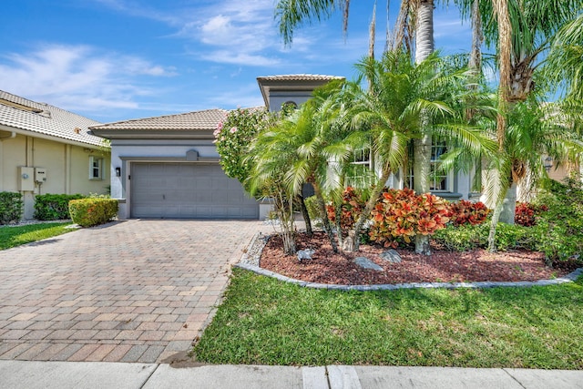 7181 Veneto Dr, Boynton Beach, FL 33437 - mediterranean / spanish house featuring decorative driveway, an attached garage, stucco siding, and a tile roof